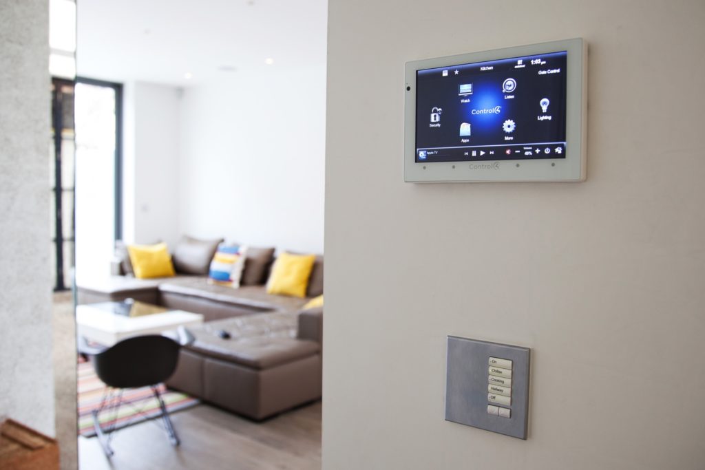Living room with a smart home control panel on the wall.