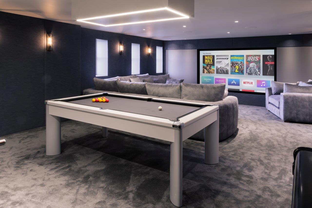 Media and games room with a large screen and a pool table.