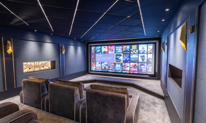 Home cinema room with screen and some chairs.